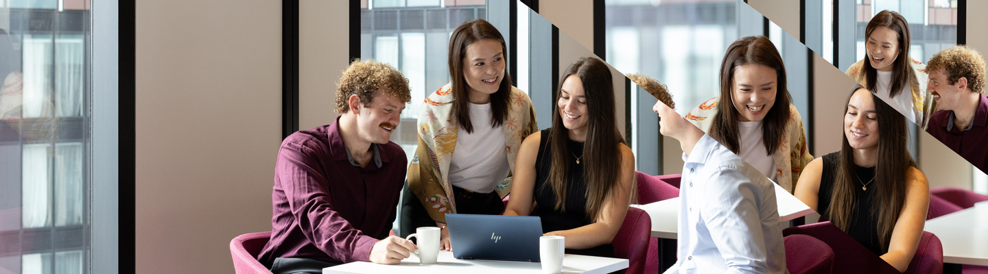 Group of colleagues looking at a laptop screen smiling