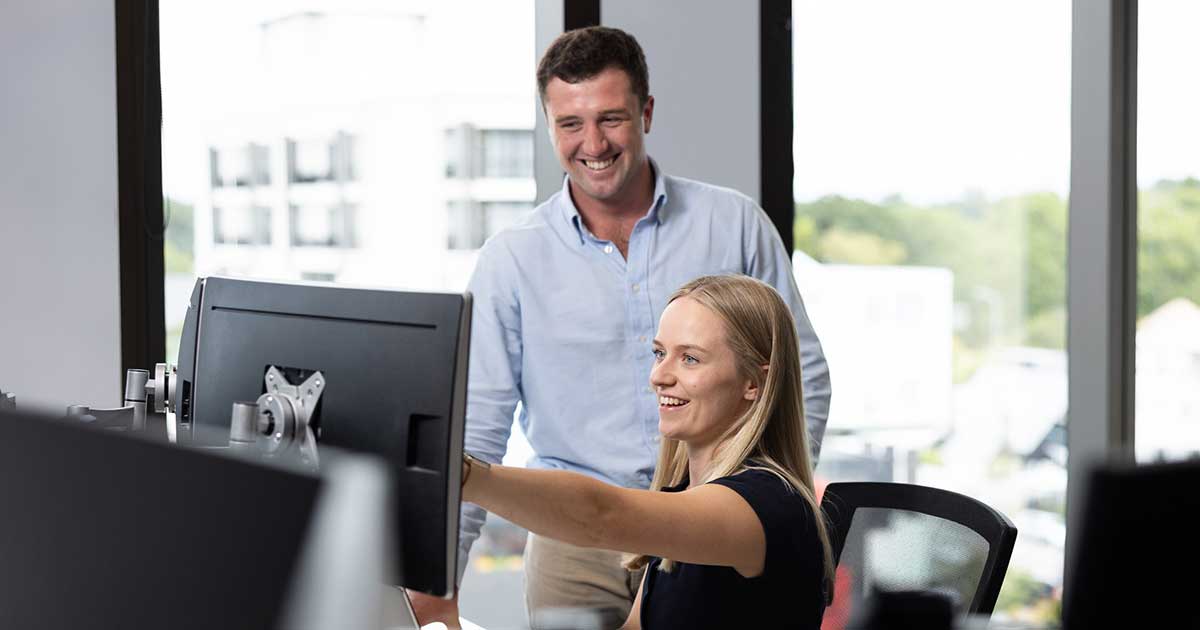 young male and female looking at computer screen