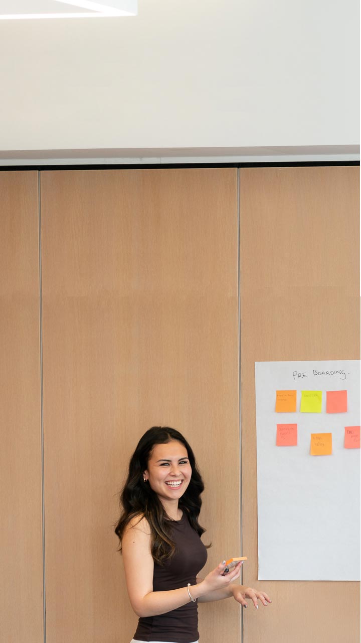 young professional female smiling writing on whiteboard