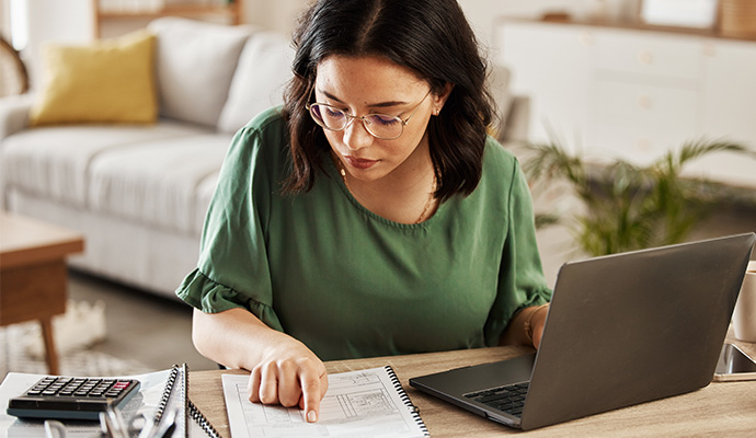 woman at home office looking at paperwork