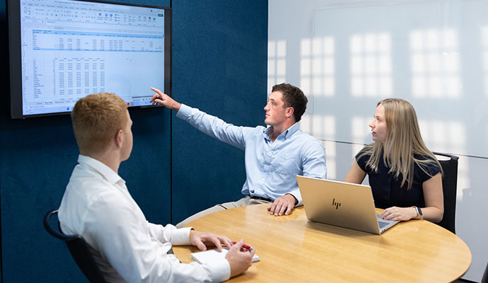 Young professionals looking at screen in meeting room